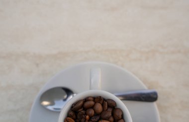 Beyaz arka planda kahve fincanı ve fasulye. Metnin için kopyalama alanı olan üst görünüm