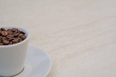 Beyaz arka planda kahve fincanı ve fasulye. Metnin için kopyalama alanı olan üst görünüm