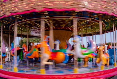 Gün batımında parkta çocuklar için atlıkarınca gezisi.