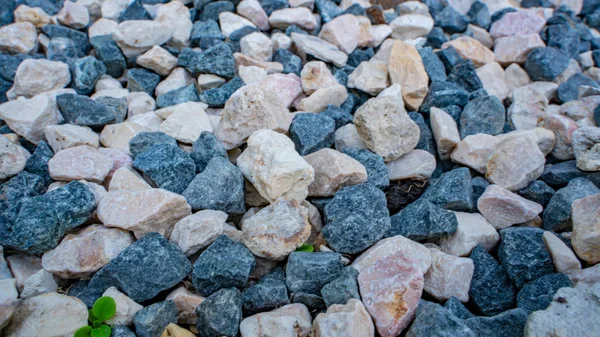 石の背景。青砂利だ。歯ざわりがいい。岩だらけの道。建設資材だ。石の質感。細かい砂利の壁紙. — ストック写真