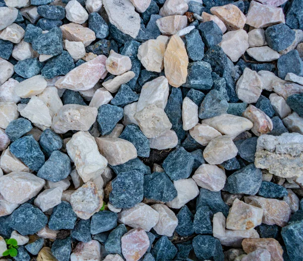 石の背景。青砂利だ。歯ざわりがいい。岩だらけの道。建設資材だ。石の質感。細かい砂利の壁紙. — ストック写真