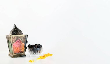 Beyaz arkaplan arkaplanlı, Arap fenerli, hurmalı ve boncuklu arkaplan resmi. Ramadhan ve Kurban Bayramı kavramı