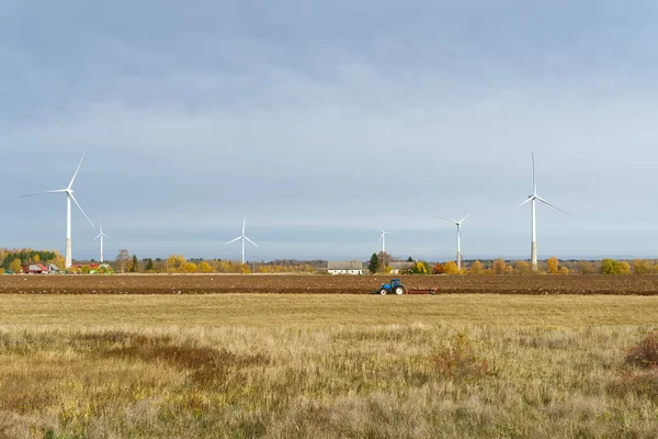green electricity produced by wind generators against the backdrop of an autumn farm