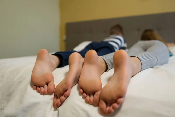 children lying in bed, kids feet close-up