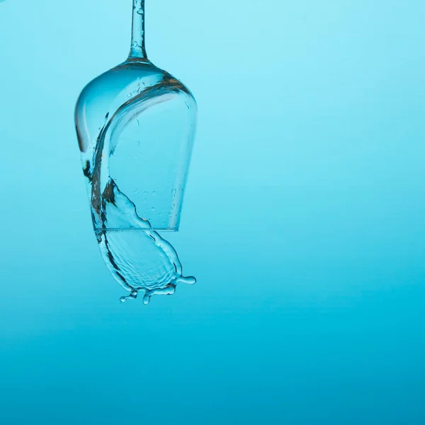 Hermosas salpicaduras de agua en una copa de vino, con filtro azul, cerca con espacio de copia . — Foto de Stock