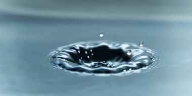 Su yüzeyine güzel bir su damlası, makro fotoğraf.