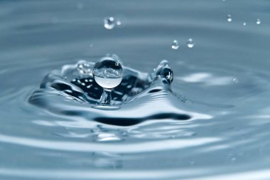 Su yüzeyine güzel bir su damlası, makro fotoğraf.