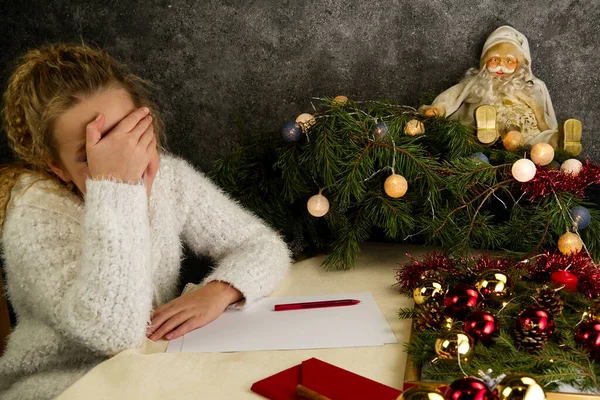 Little girl writes a letter to Santa Claus. Emotions: joy, happiness, thoughtfulness, fatigue ... Christmas should be hurried soon for Santa to make dreams come true — Stock Photo, Image