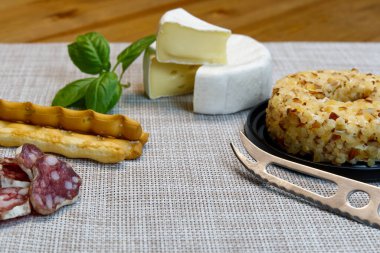 Peynir aperatifi seçimi mi yoksa peynir ve şarap partisi masası mı? Brie peyniri, ekmek çubuğu ve salam çok iştah açıcıdır..