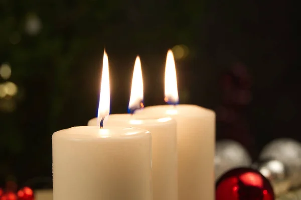 Drei brennende Kerzen mit Weihnachtsdekoration. Weihnachtskomposition. — Stockfoto