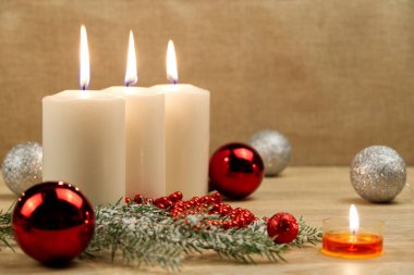 Noel süslemesiyle yanan üç mum. xmas bileşimi.