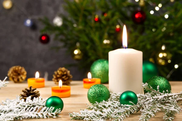 点着蜡烛和圣诞装饰品 圣诞树的绿球和木地板上的冷杉枝条，背景粗硬。 复制空间 — 图库照片