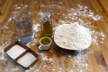 Evde İtalyan pizza hamuru yapmak için malzemeler. un, tuz, şeker, maya, zeytinyağı ve su