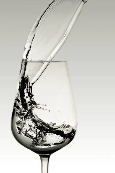 Beautiful splashes of water in a wine glass, isolate on white, close up with copy space. — ストック写真