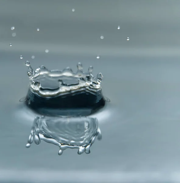 Bella spruzzata di goccia d'acqua sulla superficie dell'acqua, macro foto — Foto Stock