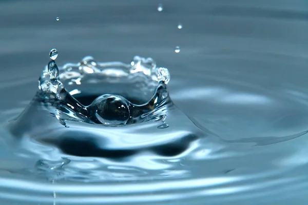 Bella spruzzata di goccia d'acqua sulla superficie dell'acqua, macro foto — Foto Stock