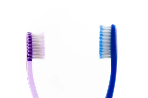 Pasangan merah muda dan biru sikat gigi di kaca di kamar mandi terisolasi di atas latar belakang putih . — Stok Foto