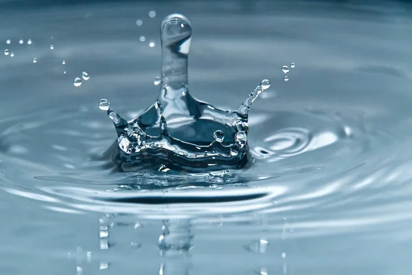 Bella spruzzata di goccia d'acqua sulla superficie dell'acqua, macro foto — Foto Stock