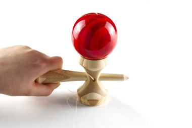 Kendama Japon tahta oyuncağı beyazın üstünde izole edilmiş. Kırmızı bal ile ahşap oyuncak.