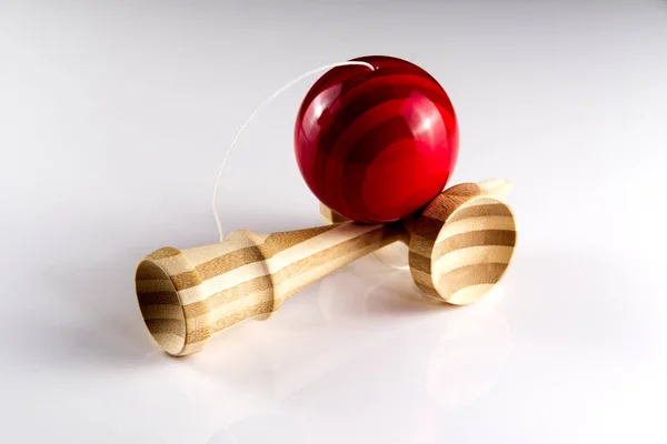Кандама япанська дерев'яна іграшка ізольована на білому. Деревина з червоним балом.. — стокове фото