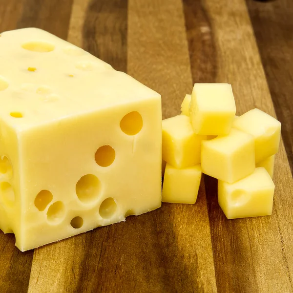 Кусок сыра крупным планом. сыр на деревянной доске — стоковое фото