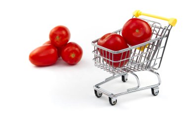 Beyaz arka planda izole edilmiş bir domates. Alışveriş arabasında olgun kırmızı domatesler. Domates ticareti konsepti. İnternetten alışveriş konsepti. Beyaz arka planda araba ve domates. iş