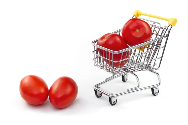Beyaz arka planda izole edilmiş bir domates. Alışveriş arabasında olgun kırmızı domatesler. Domates ticareti konsepti. İnternetten alışveriş konsepti. Beyaz arka planda araba ve domates. iş — Stok fotoğraf