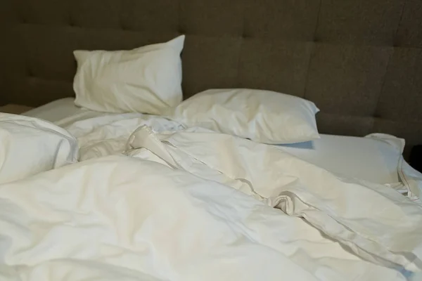 ベッドも汚れたリネンもホテルのサービスも悪い汚いホステルで快適な部屋じゃないこれはベッドが夜の試合の後にどのように見えるかです。 — ストック写真