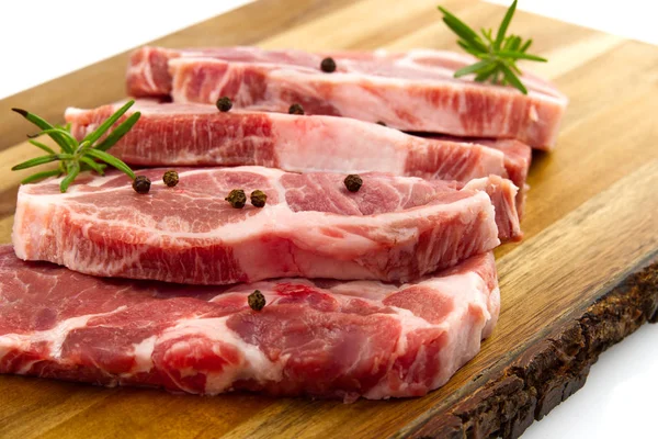 Filete de cerdo crudo en tabla de cortar madera. Cerdo con especias: romero y pimienta. Filetes de cerdo crudos de cerca . — Foto de Stock