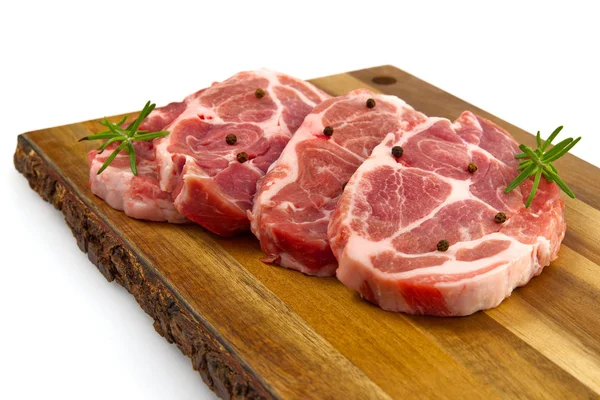 Filete de cerdo crudo en tabla de cortar madera. Cerdo con especias: romero y pimienta. Filetes de cerdo crudos de cerca . — Foto de Stock