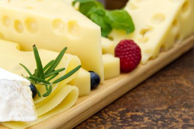 Tahtada dilimlenmiş zeytinli ve biberiyeli peynir. şarap peyniri aperatifi