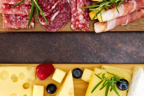 Snack antipasti de carne y queso con jamón Prosciutto, queso parmesano, queso azul, melón melón y aceitunas sobre tabla de servir de madera de olivo con espacio para copiar — Foto de Stock