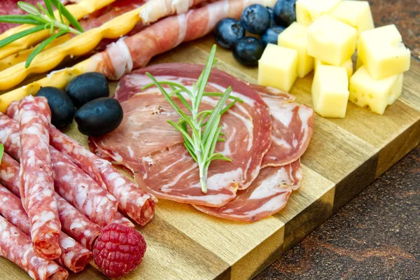 Hermoso arreglo de comida en rodajas foto de cerca. Plato antipasto estilo italiano, queso, jamón, salami, rosmarin, prosciutto — Foto de Stock