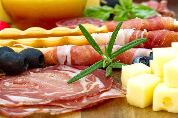Hermoso arreglo de comida en rodajas foto de cerca. Plato antipasto estilo italiano, queso, jamón, salami, rosmarin, prosciutto — Foto de Stock