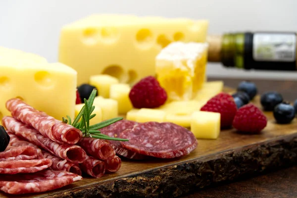 Vackra skivad mat arrangemang närbild. Italiensk stil antipasto platta, ost, skinka, salami, rosmarin, prosciutto — Stockfoto