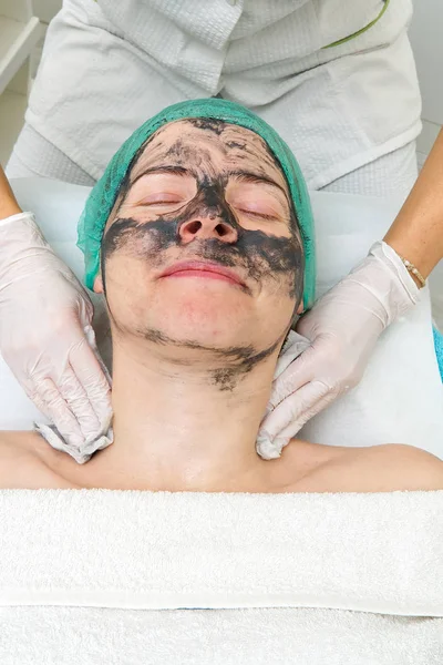 Vackrare tvättar bort en naturlig fuktgivande mask i ansiktet på en ung vacker kvinna. Svart bambumask. Närbild — Stockfoto