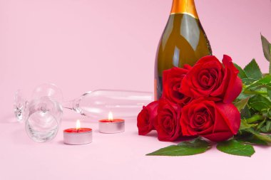 Güzel bir gül buketi, mumlar, bardaklar ve bir şişe şampanya romantik bir kart oluşturur. Sevgililer Günü konsepti, Anneler Günü, 8 Mart.