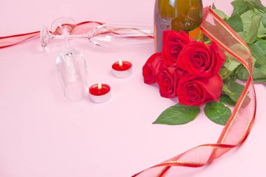 Güzel bir gül buketi, mumlar, bardaklar ve bir şişe şampanya romantik bir kart oluşturur. Sevgililer Günü konsepti, Anneler Günü, 8 Mart.