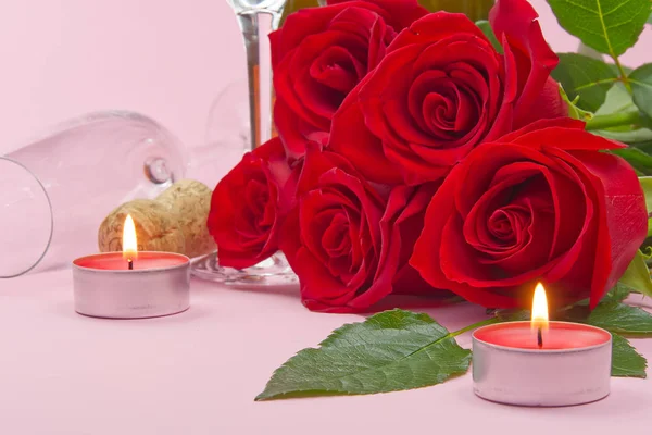 Una composizione di un bellissimo bouquet di rose, candele, bicchieri e una bottiglia di champagne crea una carta romantica. Il concetto di San Valentino, Festa della Mamma, 8 marzo . — Foto Stock