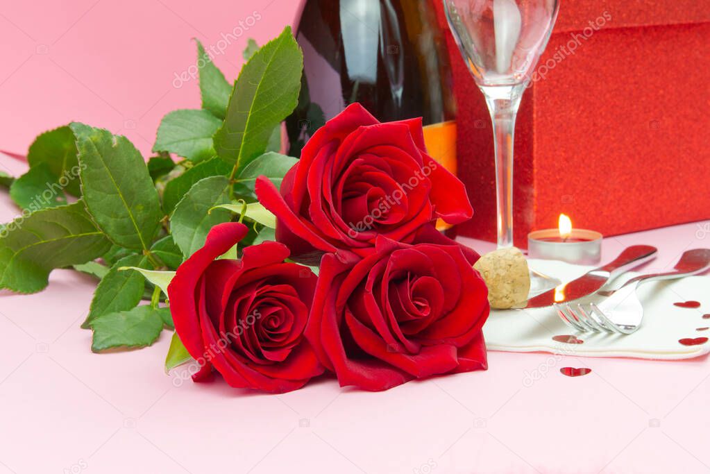 a composition of a beautiful bouquet of roses, glasses and a bottle of champagne creates a romantic card or poster. The concept of st valentine's day, Mother's Day, March 8.