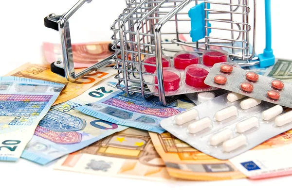 Μεμονωμένο καλάθι αγορών γεμάτο φάρμακα με χάπια και κάψουλες και τραπεζογραμμάτια ευρώ. Λεφτά. έννοια του κόστους των ναρκωτικών — Φωτογραφία Αρχείου