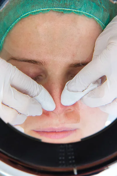 Beautician removes - squeezes acne from the face of a young beautiful girl. The concept of cosmetology. The cosmetologist performs the procedure to cleanse the face with problem skin. under cosmetic — Stockfoto