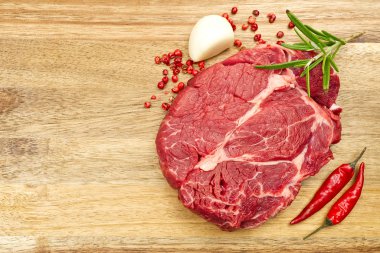 Tahta manzaralı çiğ biftek. Baharatlı taze biftek pişirmeye hazır..