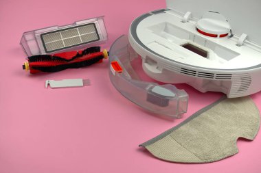 Pembe arka planda beyaz robot elektrikli süpürge. Temizlikten sonra robot elektrik süpürgesini temizleme prosedürü. gelecek ev teknolojisi.