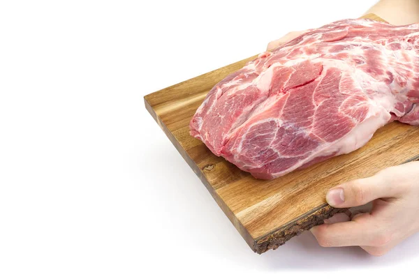 Fresh raw pork neck on wooden cutting board isolated on white. Male hand holding cutting board with pork meat. — Stock Photo, Image