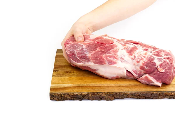 Pescoço de porco cru fresco em tábua de corte de madeira isolada em branco. Mão masculina segurando placa de corte com carne de porco . — Fotografia de Stock