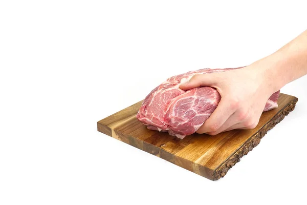 Świeży surowy kark wieprzowy na drewnianej desce do krojenia izolowany na białym. mężczyzna ręka gospodarstwa deska cięcia mięsa wieprzowego. — Zdjęcie stockowe