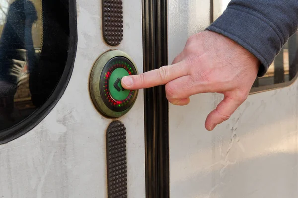 Ο άνθρωπος πατάει ένα κουμπί για να ανοίξει τις πόρτες του τρένου. κοντινό πλάνο — Φωτογραφία Αρχείου