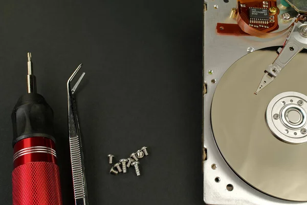 Hdd - hard disk drive. Hard disk repair concept. The hard drive is designed to store data of all mankind, so timely monitoring is very important. Pc industry. Disassembled hard disk on black or dark