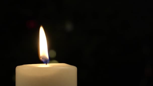 Close up of white burning candle on the table with golden light background blur — Stok video